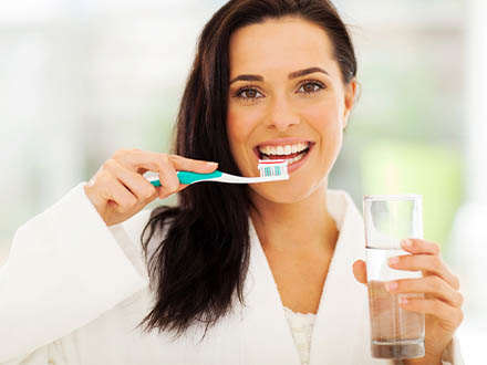 Mladá žena si čistí zuby kartáčkem
