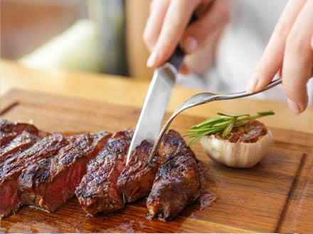 železo - ženské ruce krájí steak