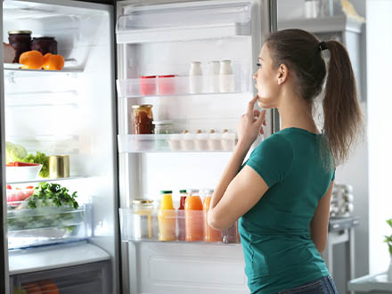 žena hledající potraviny v lednici