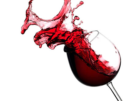 Červené víno stříká ze sklenice